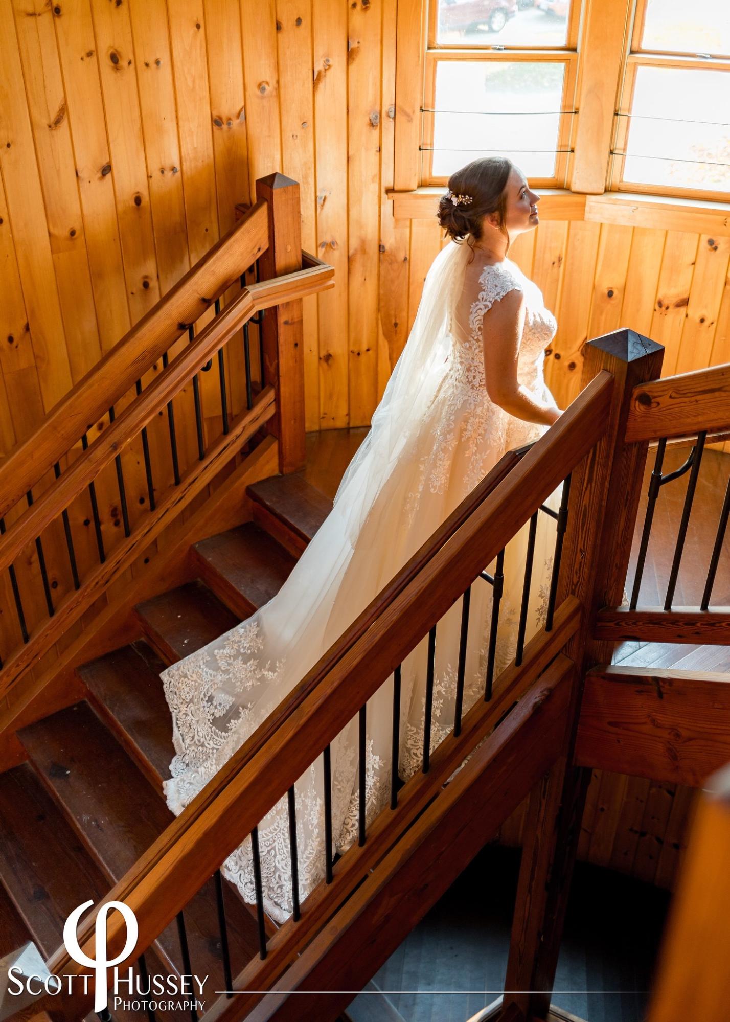 A country bride is walking down the stairs in her wedding dress.
