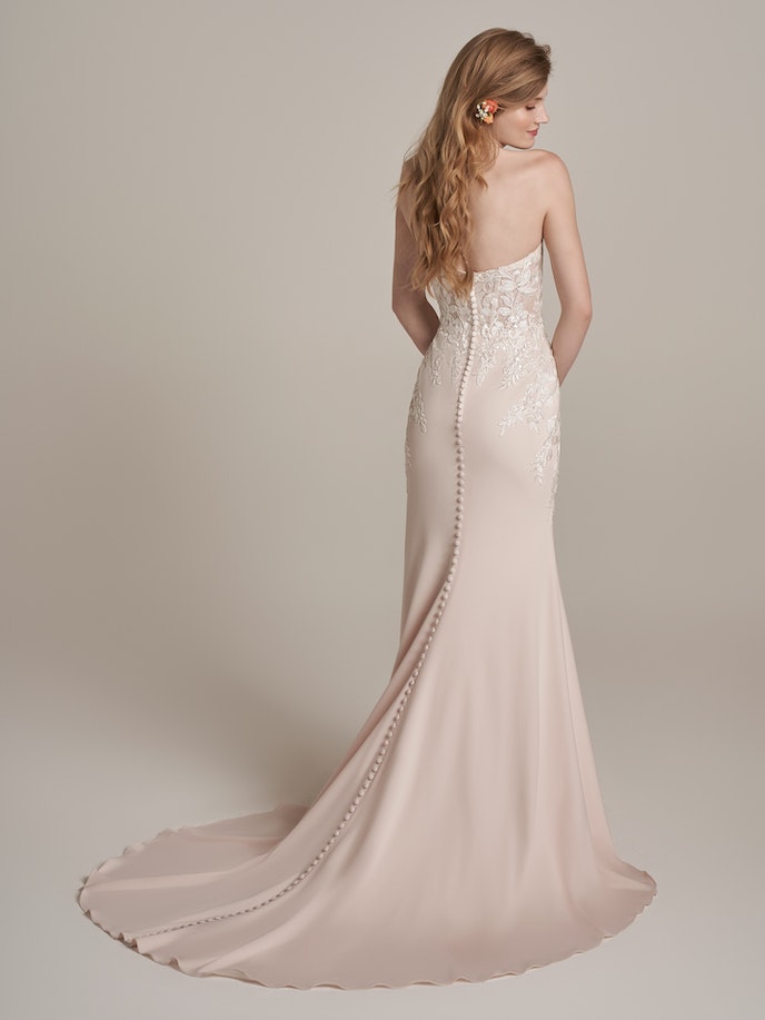 The back view of a woman in a blush wedding dress, known as the Lily Wedding Dress.