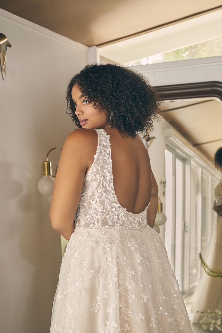 The lilac-clad back of a woman in a wedding dress.