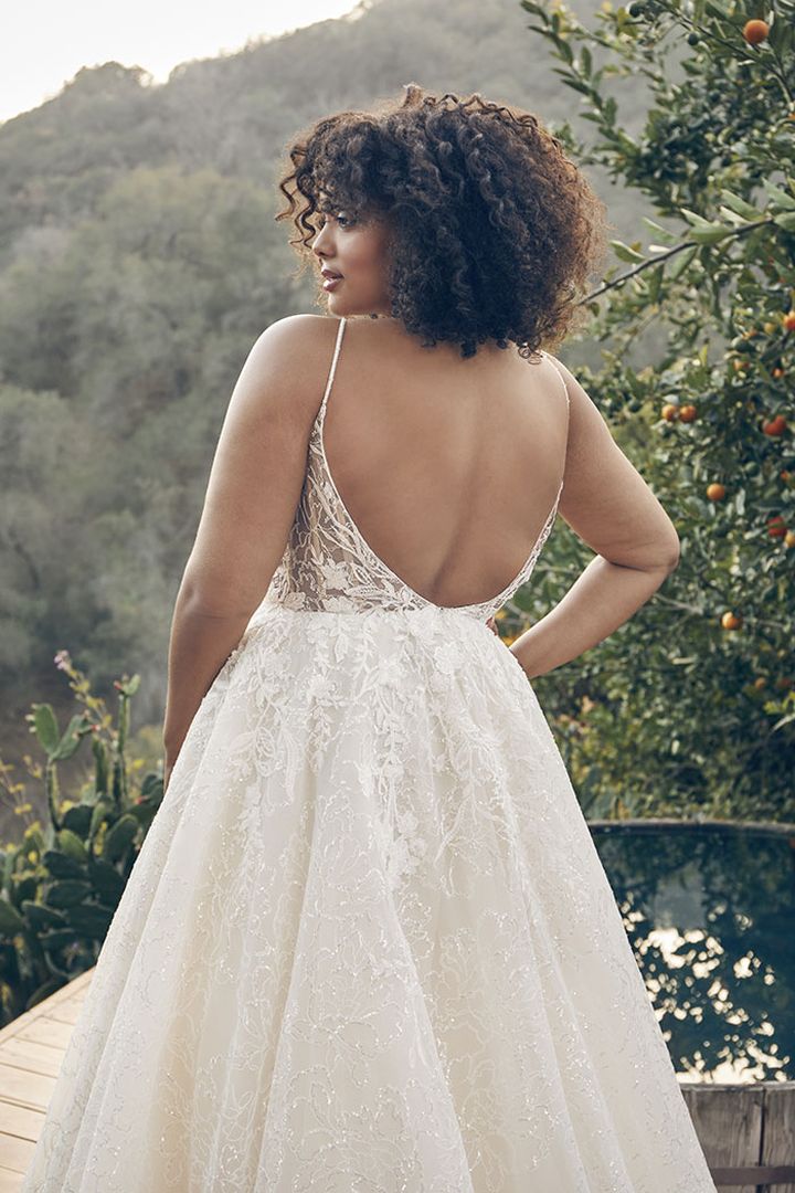 The back view of a woman in a plus size wedding dress.